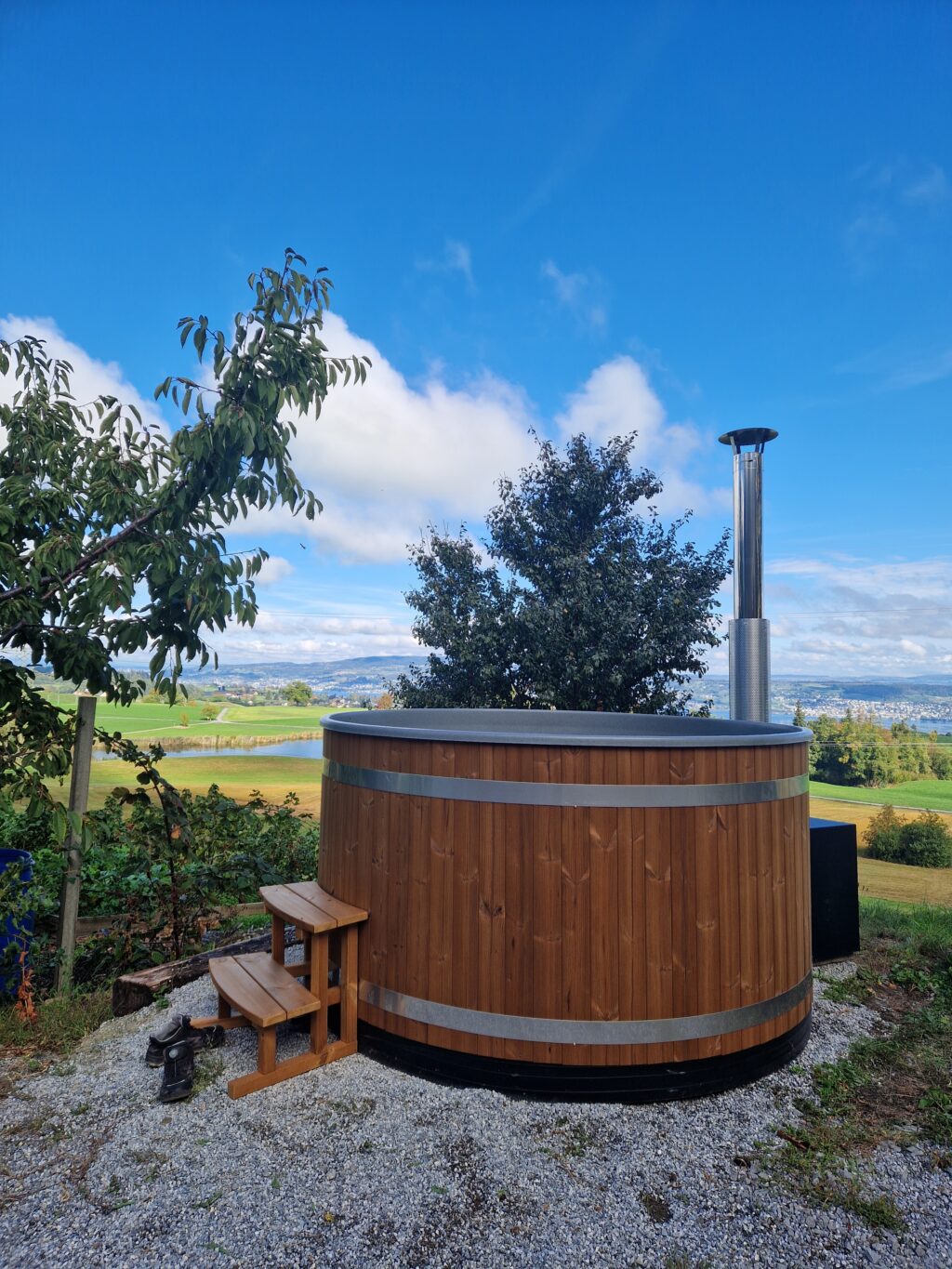 Holzbefeuertes Badefass auf dem Allenwindenhof, im Hintergrund der Zürichsee