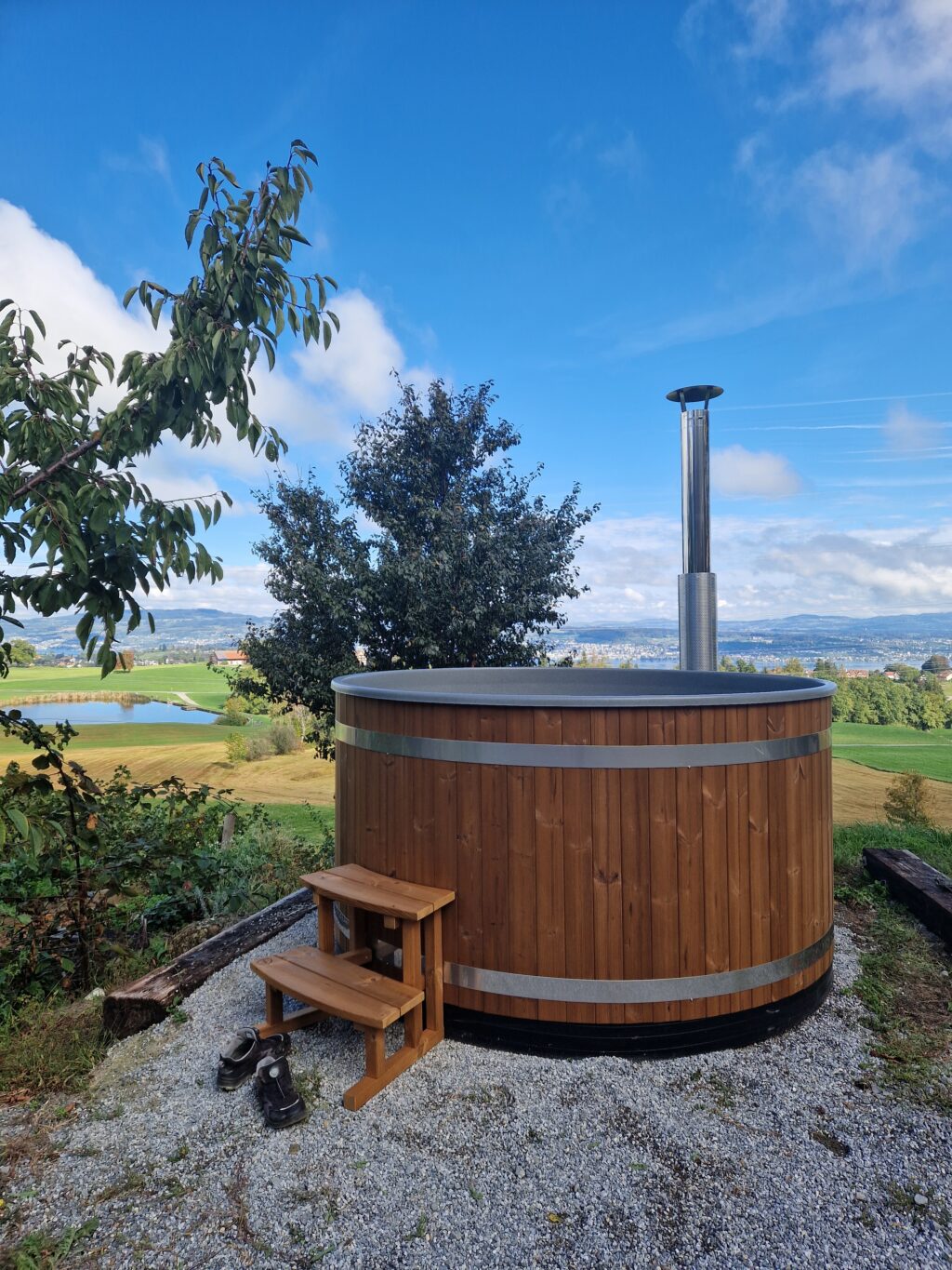 Holzbefeuertes Badefass auf dem Allenwindenhof, im Hintergrund der Zürichsee